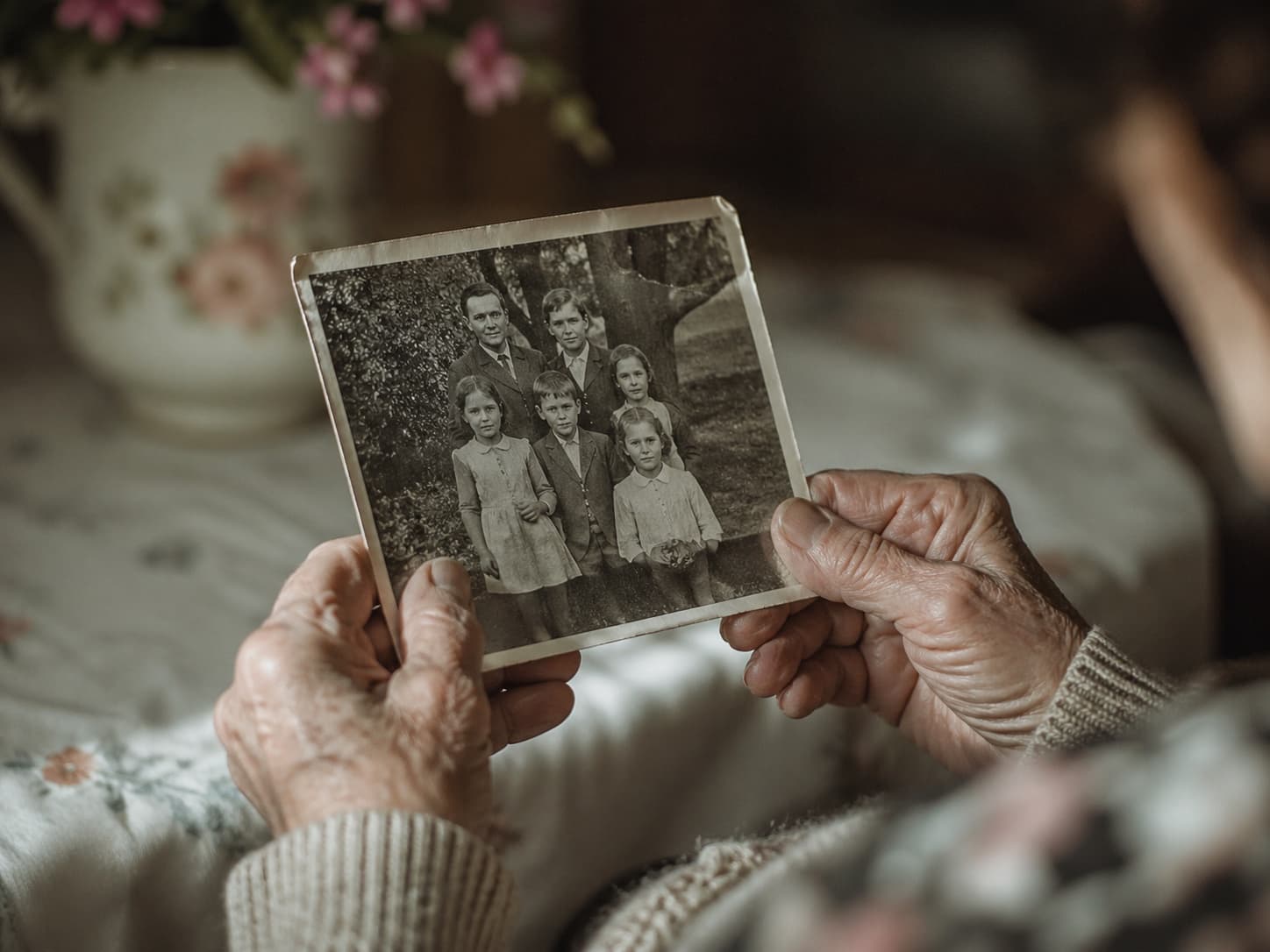 Ältere Hände halten ein altes Familienfoto