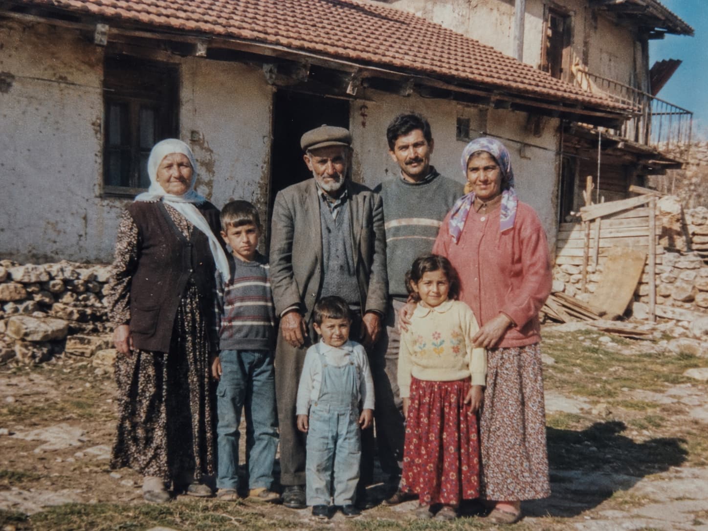 Türkische Familie steht vor altem Dorfhaus